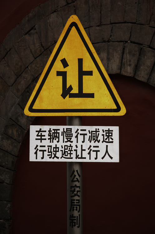 The photo (b) shows a sign with writing in Chinese.