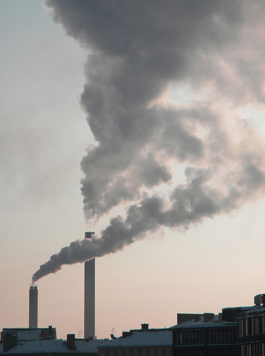  This photo shows a smokestack from a factory churning gray smoke into the air.