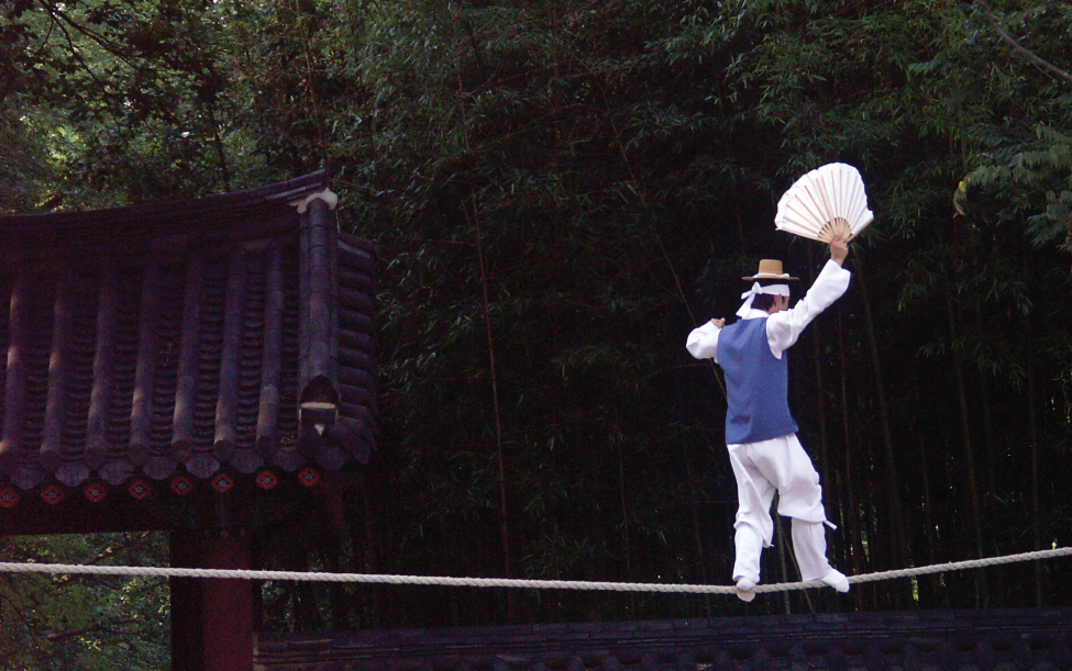 This photograph shows a man balancing on a tightrope.