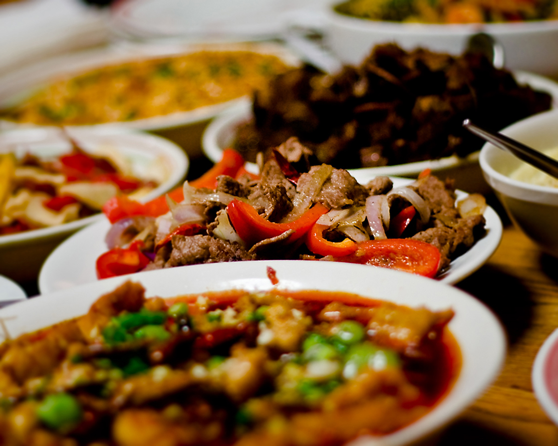 Photo shows plates of food on a dinner table.