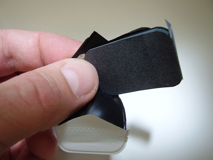 Image shows fingers holding a black strip of film on a radioactive rock.