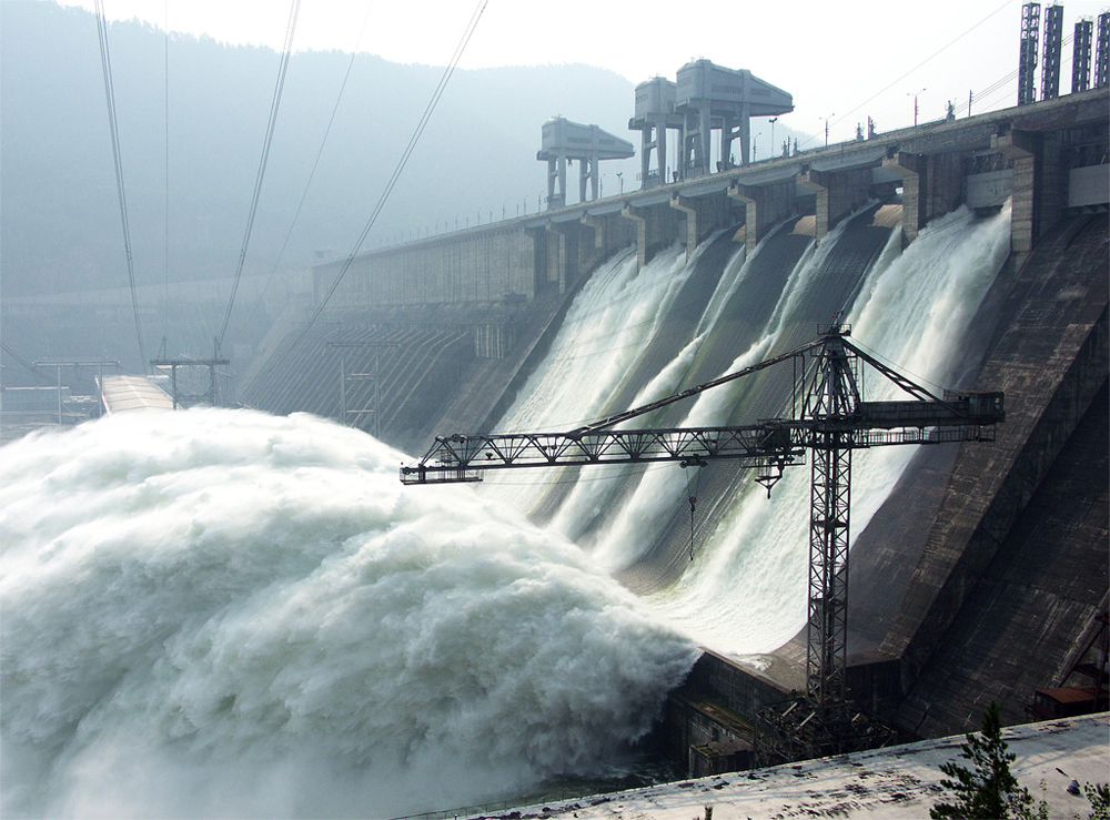 A dam with water flowing down its gates.