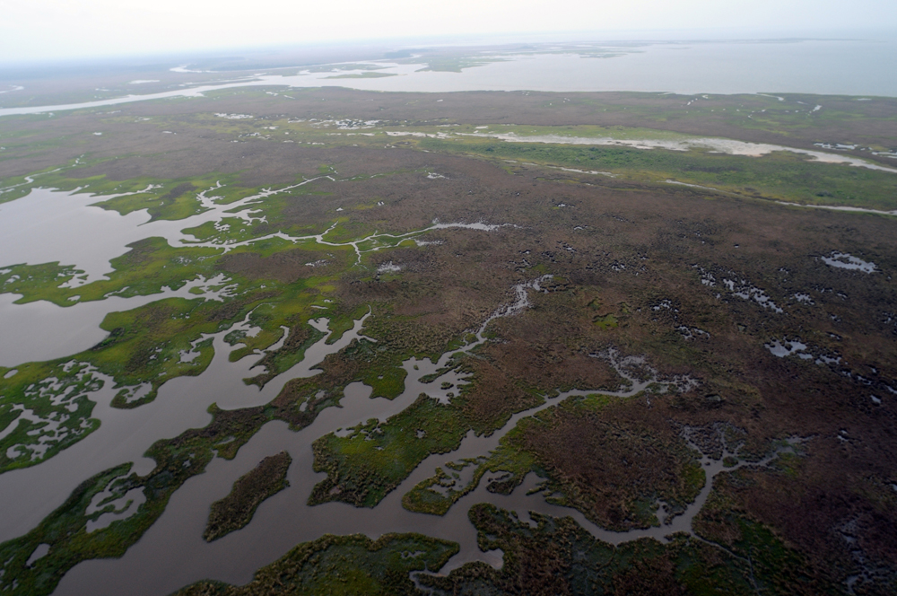 An airplane view of oil-clogged sandbars and the surrounding ocean water tainted by oil is shown here.