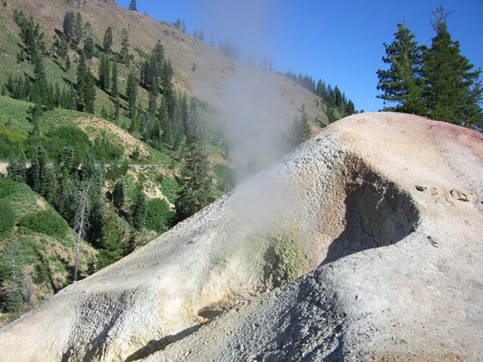  This photo shows a white pyramid-shaped mound with gray steam escaping from it.