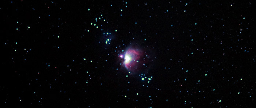 Night sky with bright Orion Nebula cluster in the center amongst the group of stars.