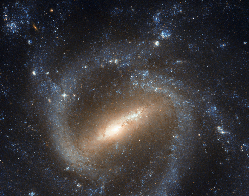 Image of a Barred-Spiral Galaxy. Just below center is the elongated central bar tilted about 45-degrees from the bottom of the frame. At each end of the bar begin the spiral arms, twisting clockwise around the central bar and encircling the whole galaxy.