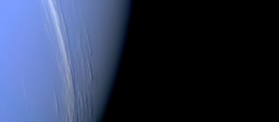 The White Clouds of Neptune. Thin clouds of methane ice crystals run nearly vertically from top to bottom center in this Voyager image of Neptune. These clouds have the appearance of cirrus clouds frequently seen on Earth.