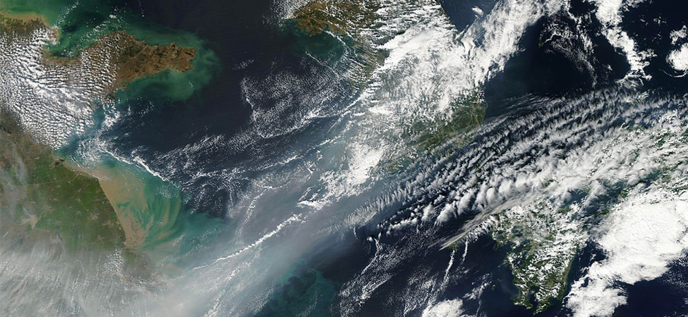 A satellite photograph of northeastern China. Clouds cover part of the view. The bottom left part of the image is obscured by smog.