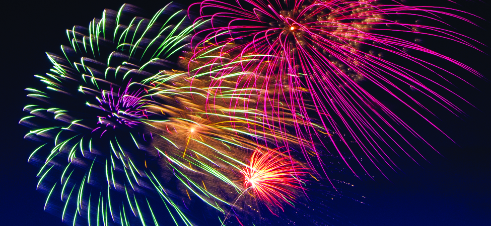 A photo of multi-colored fireworks exploding in a night sky.